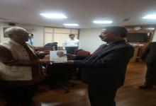Prof. Oommen presenting book to Justice H.L. Dattu